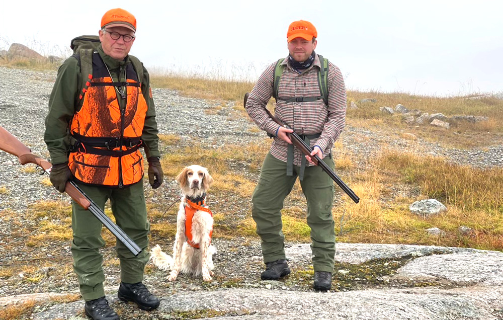 Lars Peder Brekk er til venstre på bildet, med hund og jeger.